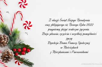 Kartka bożonarodzeniowa z przyzdobionym igliwiem na której znajdują się życzenia z okazji Świąt 